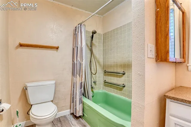 a bathroom with a granite countertop sink a toilet and shower