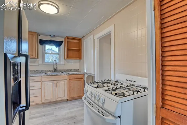 a view of a kitchen with stove and cabinets