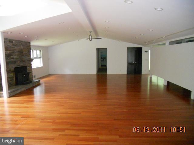 a view of empty room with wooden floor and fireplace