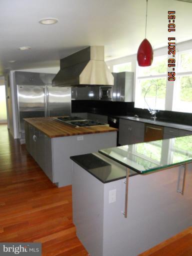 2403 Logan Road Owings Mills, MD 21117 - Photo 14 of 15 a kitchen with stainless steel appliances granite countertop a sink a stove and a microwave