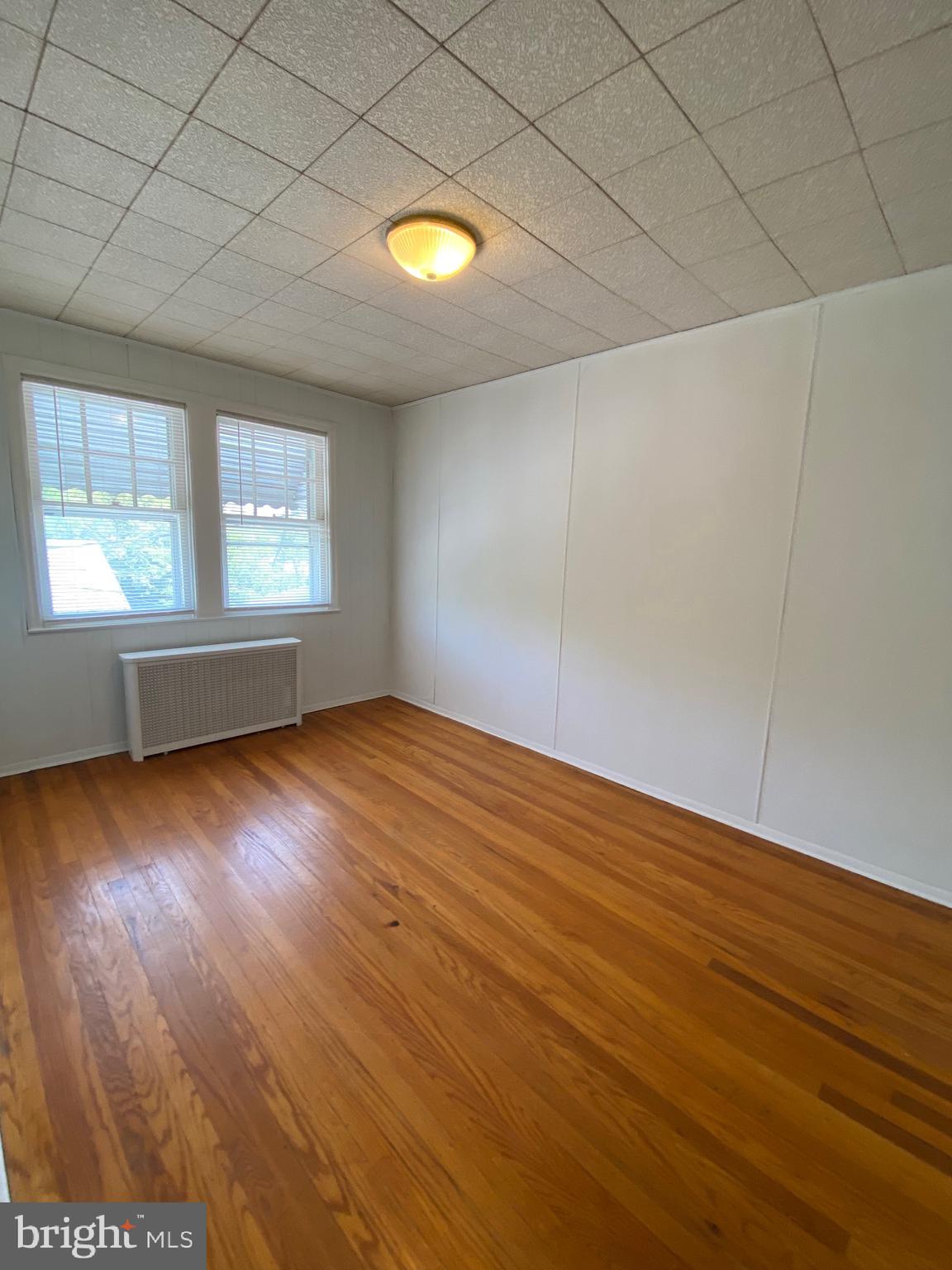 4010 Century Road Baltimore, MD 21206 - Photo 11 of 17 an empty room with wooden floor and windows in a room