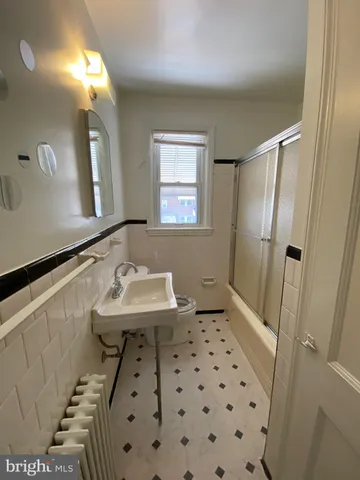 a bathroom with a sink a toilet a mirror and shower