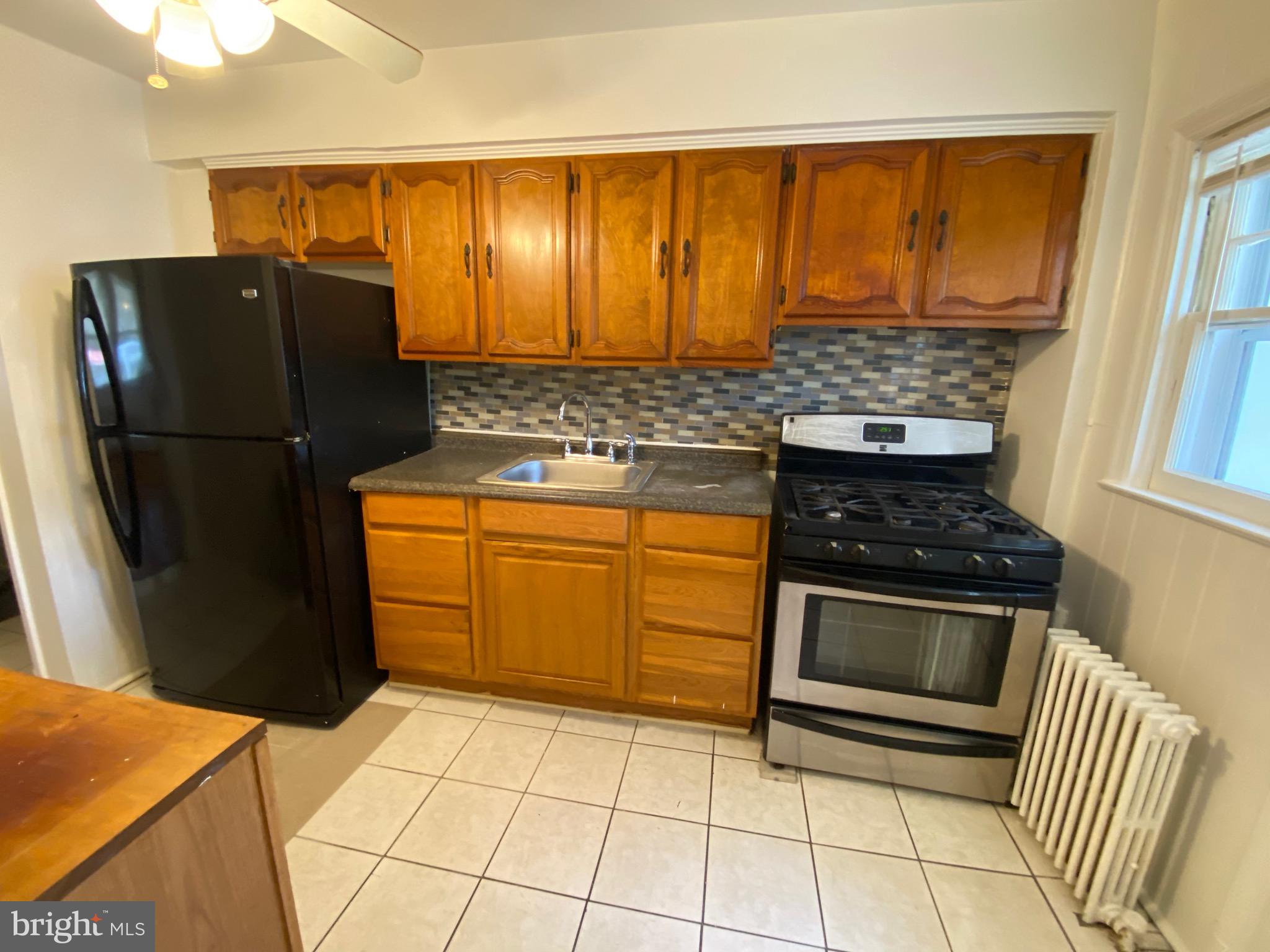 4010 Century Road Baltimore, MD 21206 - Photo 6 of 17 a kitchen with granite countertop a refrigerator and a stove top oven