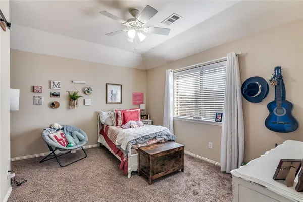 a spacious bedroom with a bed and a chandelier