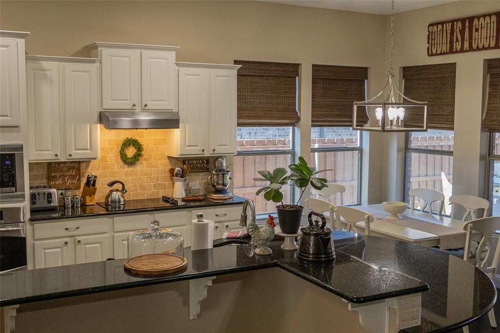 1395 Southern Rockwall, TX 75087 - Photo 6 of 22 a kitchen with a stove a sink and cabinets