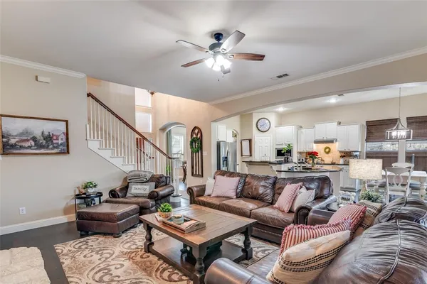 a kitchen with stainless steel appliances granite countertop a sink dishwasher a refrigerator and a dining table with wooden floor