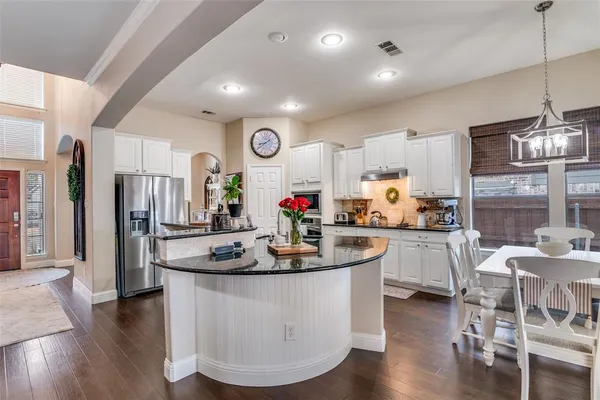 a kitchen with stainless steel appliances granite countertop a sink a stove and cabinets