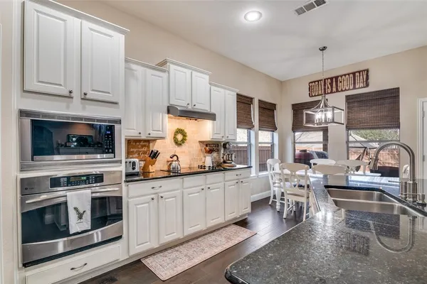 a kitchen with stainless steel appliances granite countertop a sink and cabinets