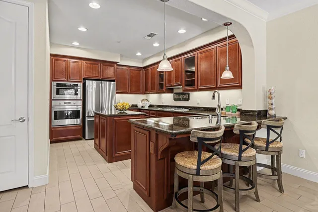 a kitchen with stainless steel appliances granite countertop a stove and a refrigerator