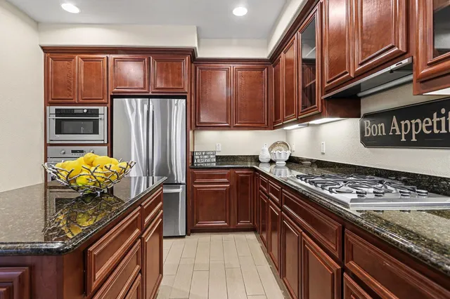 a kitchen with granite countertop stainless steel appliances and cabinets