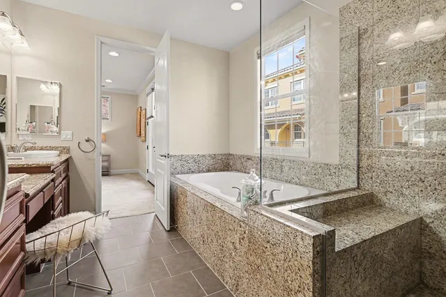 a spacious bathroom with a tub sink and mirror