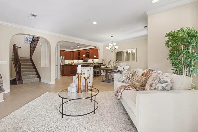 a living room with furniture gym equipment and a chandelier