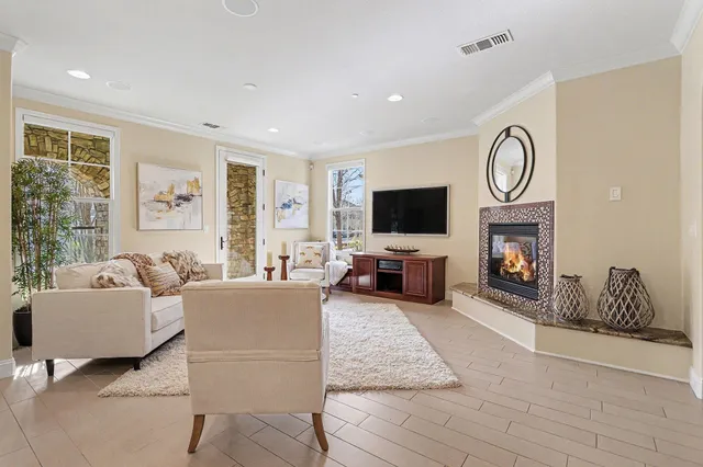 a living room with furniture a fireplace and a flat screen tv