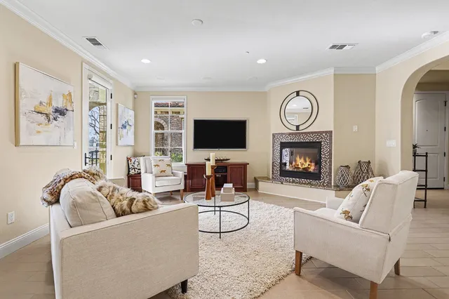 a living room with furniture a flat screen tv and a fireplace