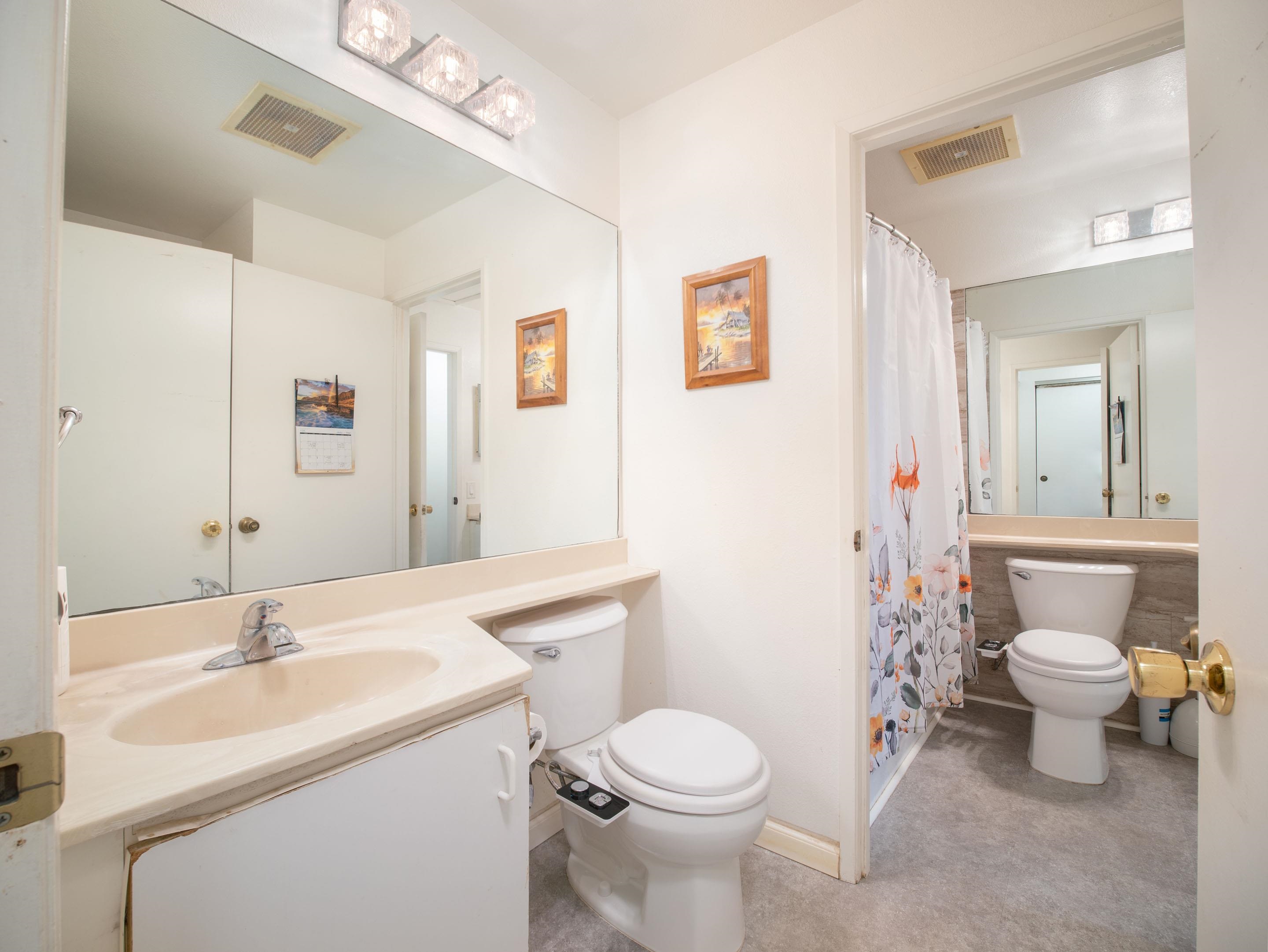 480 Kenolio Road, Unit 30206 Kihei, HI 96753 - Photo 11 of 20 a bathroom with a toilet sink and mirror