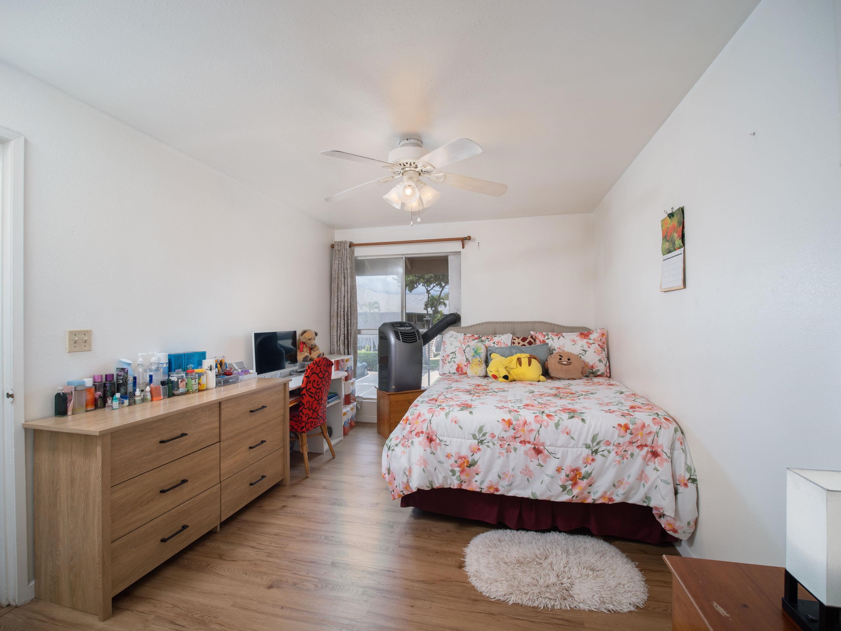 480 Kenolio Road, Unit 30206 Kihei, HI 96753 - Photo 8 of 20 a bedroom with bed and a chandelier