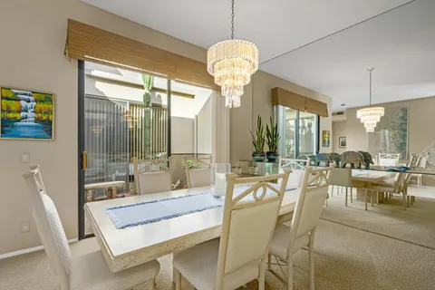 a dining room with furniture a chandelier and pool table