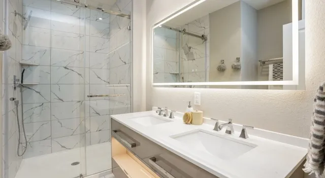 a bathroom with a sink shower and a mirror