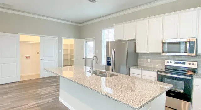 a kitchen with stainless steel appliances granite countertop a sink refrigerator and cabinets