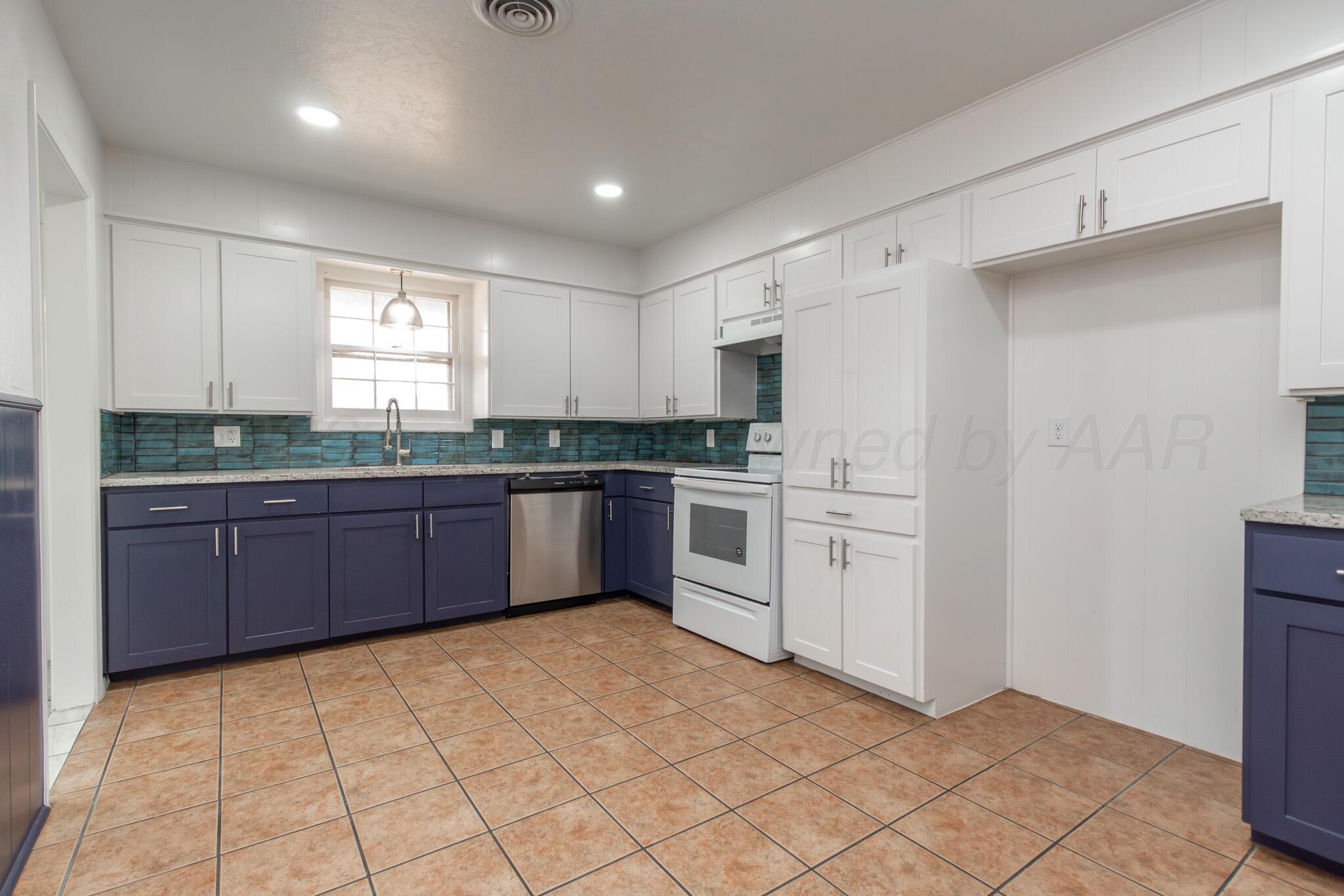 4216 Southwest 38th Avenue Amarillo, TX 79109 - Photo 8 of 19 a large kitchen with a stove top oven sink and cabinets