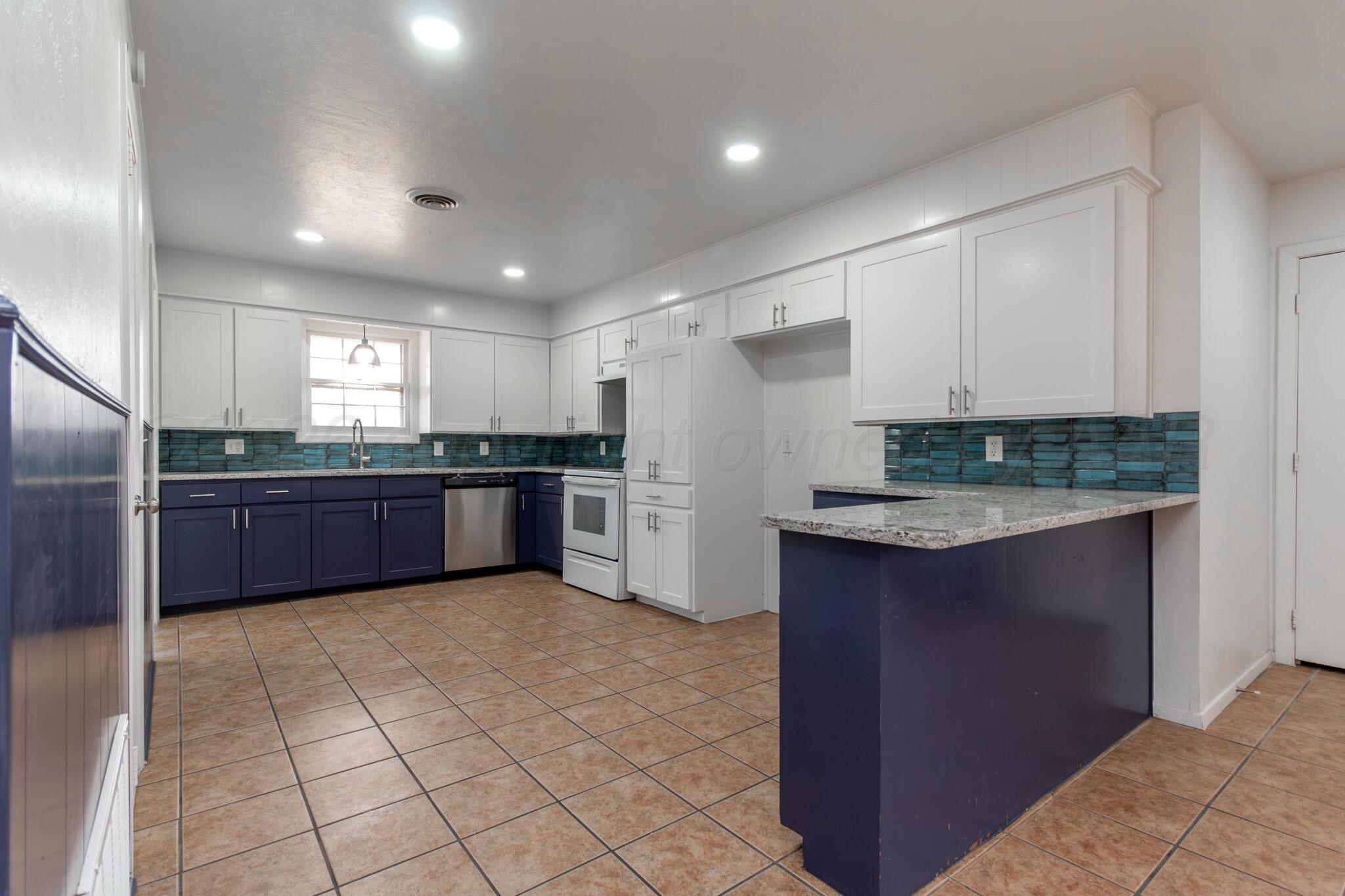 4216 Southwest 38th Avenue Amarillo, TX 79109 - Photo 10 of 19 a large kitchen with granite countertop a stove a sink and a refrigerator