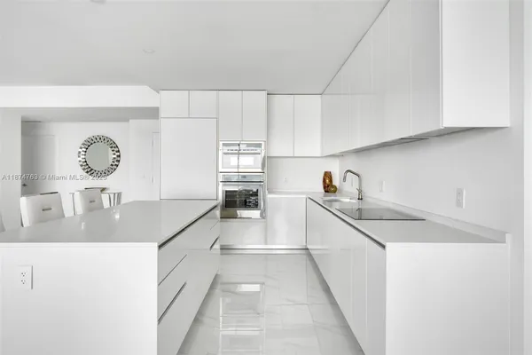 a kitchen with granite countertop a sink a stove and cabinets
