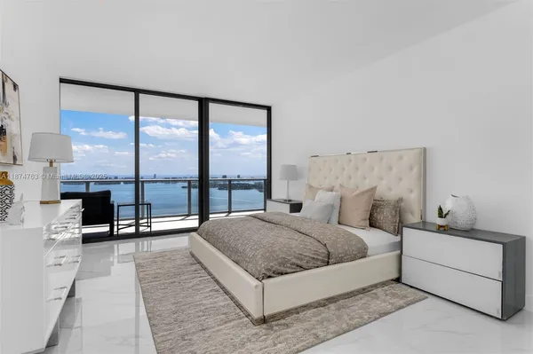 a bedroom with a bed and a large window