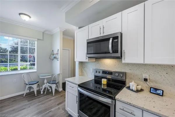 a kitchen with stainless steel appliances granite countertop a stove a microwave a sink and cabinets