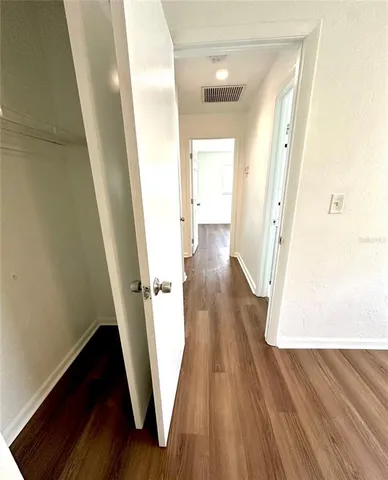 a view of a hallway with wooden floor and staircase