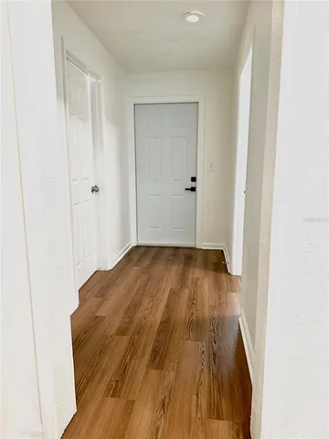 a view of a room with wooden floor and a bathroom