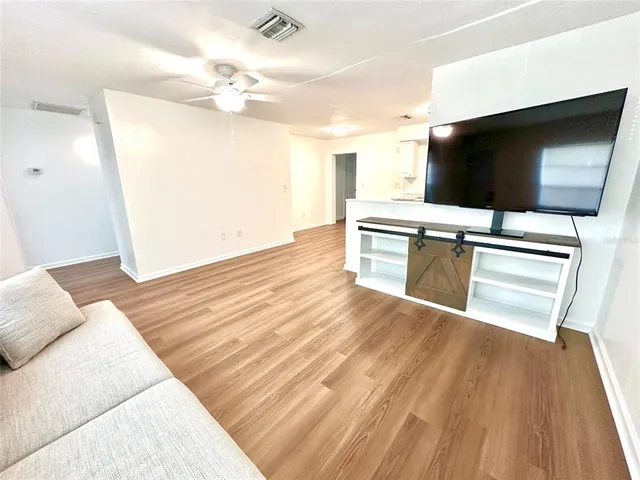 a view of a livingroom with wooden floor and a flat screen tv