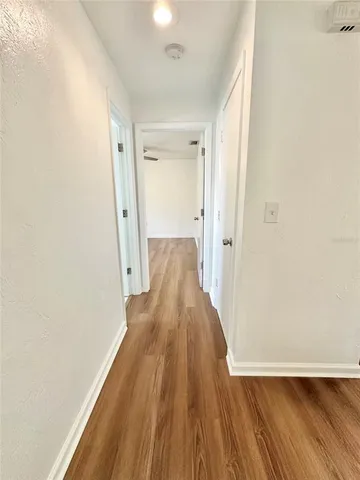 a view of a hallway with wooden floor