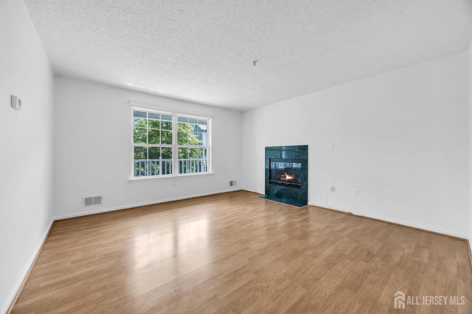 187 Prestwick Way Edison, NJ 08820 - Photo 8 of 23 an empty room with wooden floor and windows