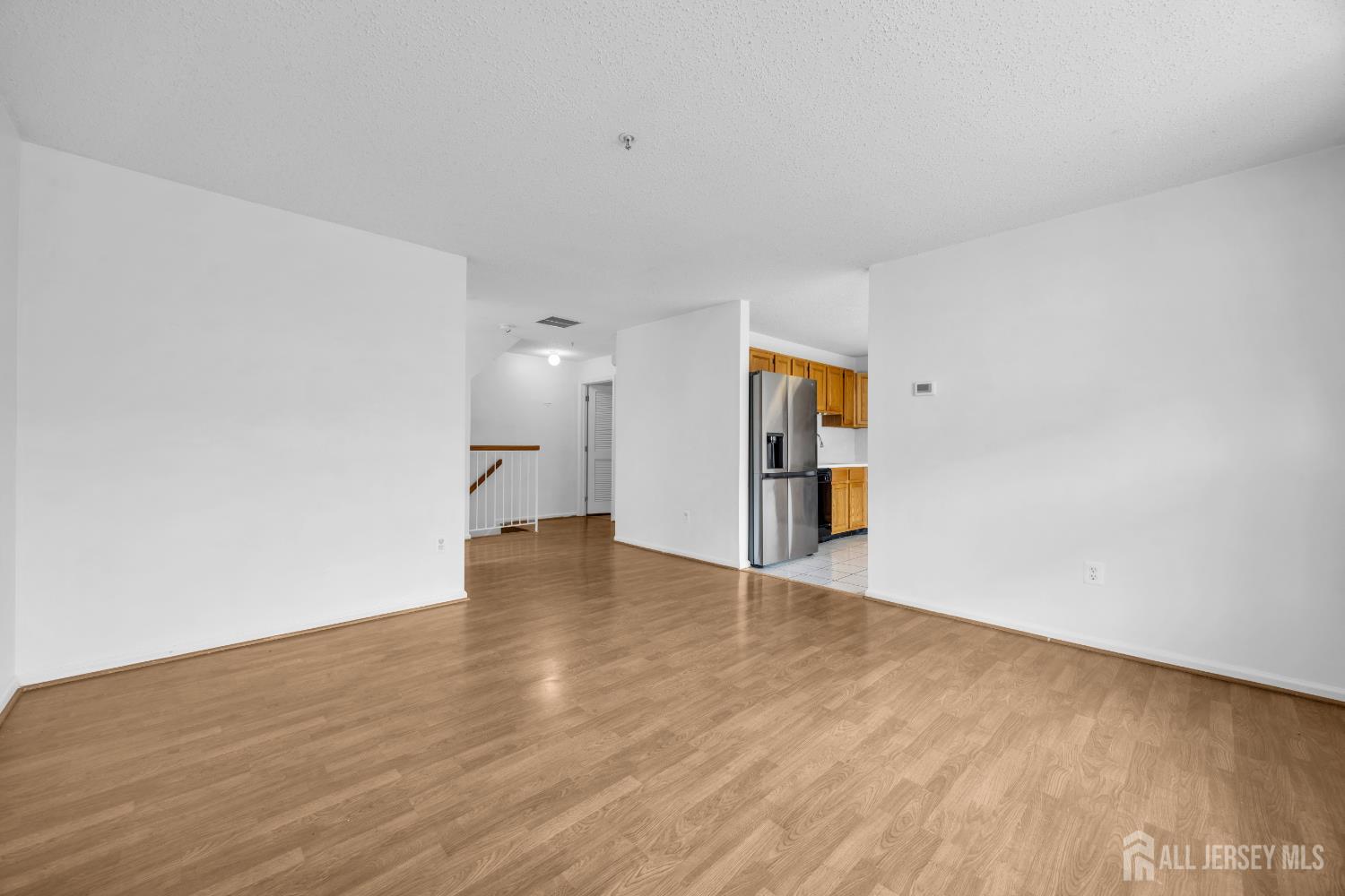 187 Prestwick Way Edison, NJ 08820 - Photo 9 of 23 a view of an empty room with wooden floor and a window
