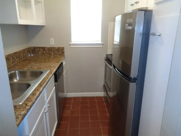 a kitchen with metallic refrigerator and a stove