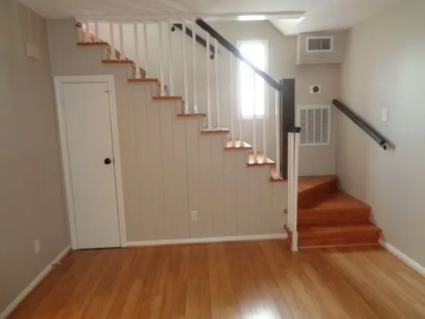a view of hallway with stairs and wooden floor