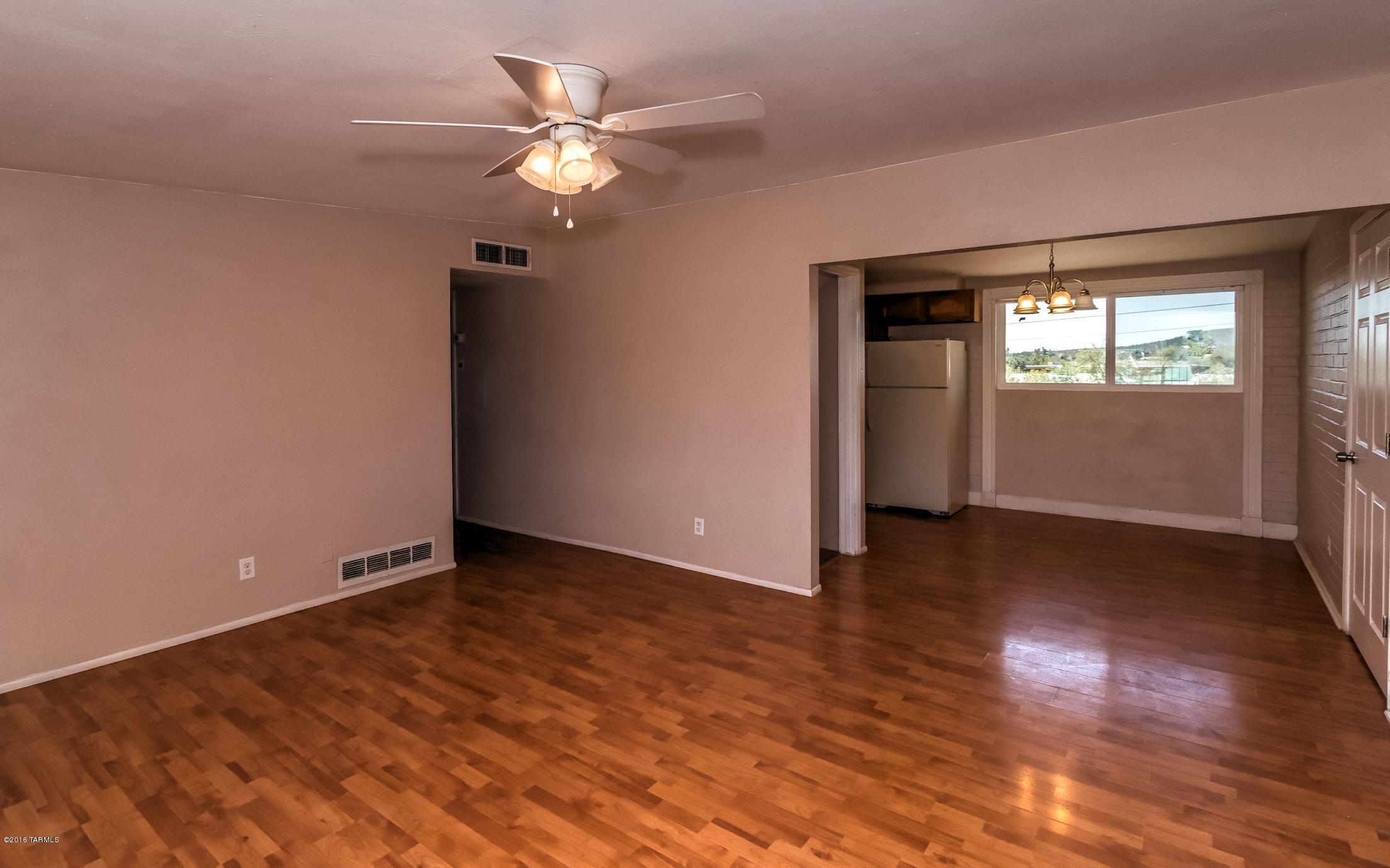 1807 West Merlin Road Tucson, AZ 85713 - Photo 10 of 34 an empty room with wooden floor and windows