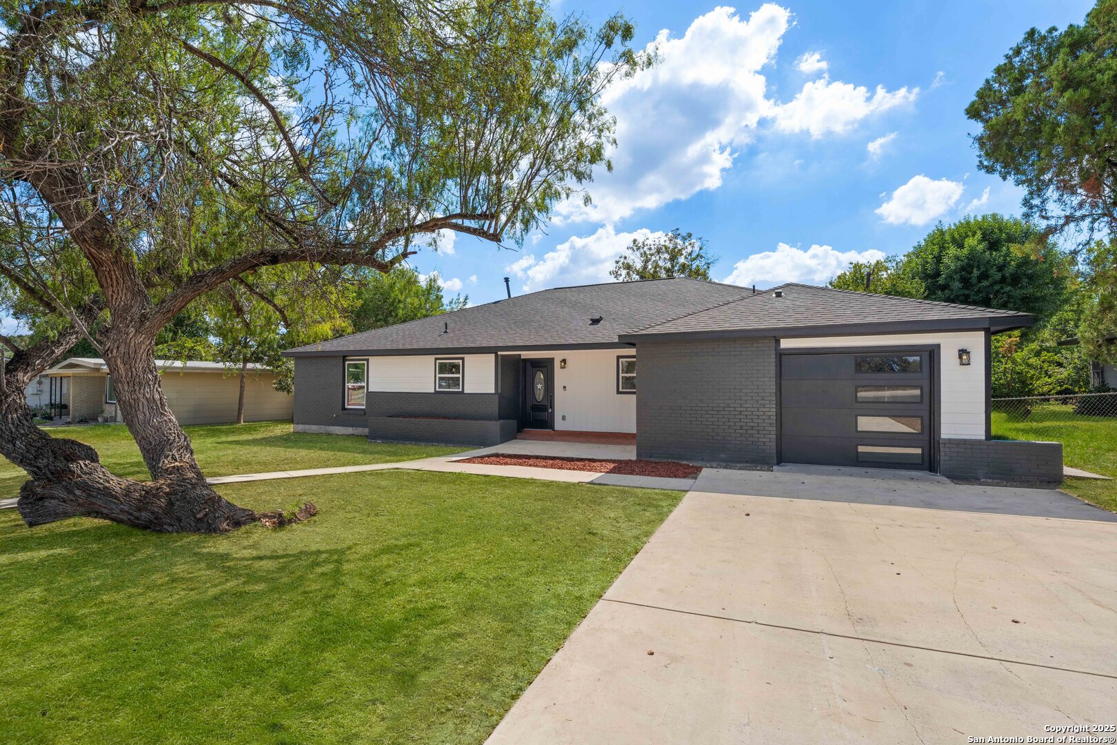 246 Sprucewood Lane San Antonio, TX 78216 - Photo 6 of 42 a front view of a house with a garden and trees