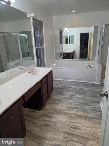 a spacious bathroom with a double vanity sink a mirror and shower