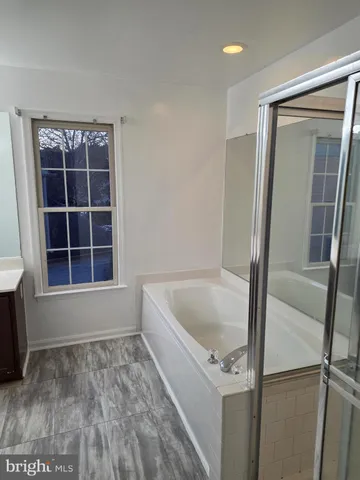 a bathroom with a tub and a window