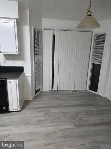 a view of a livingroom with wooden floor and a fireplace