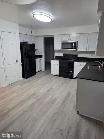 a kitchen with stainless steel appliances granite countertop a refrigerator and a stove
