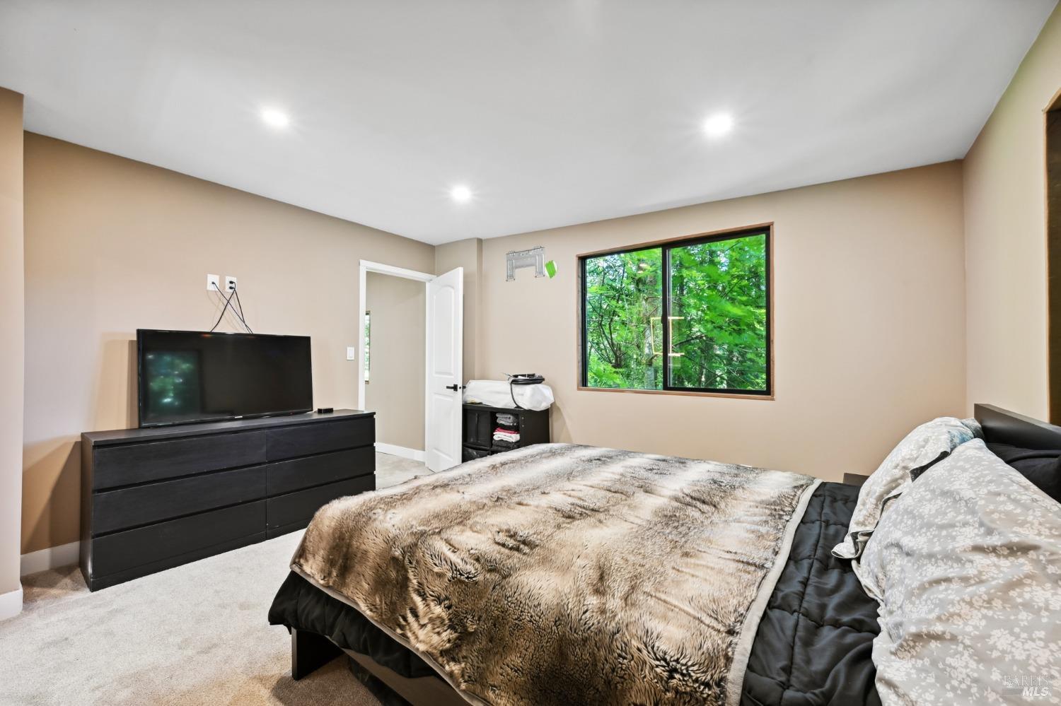 21713 Starrett Hill Drive Monte Rio, CA 95462 - Photo 27 of 50 a bedroom with a bed and a flat screen television