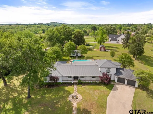 a aerial view of a house with swimming pool and a yard