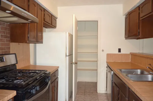 a kitchen with granite countertop a sink stove and refrigerator
