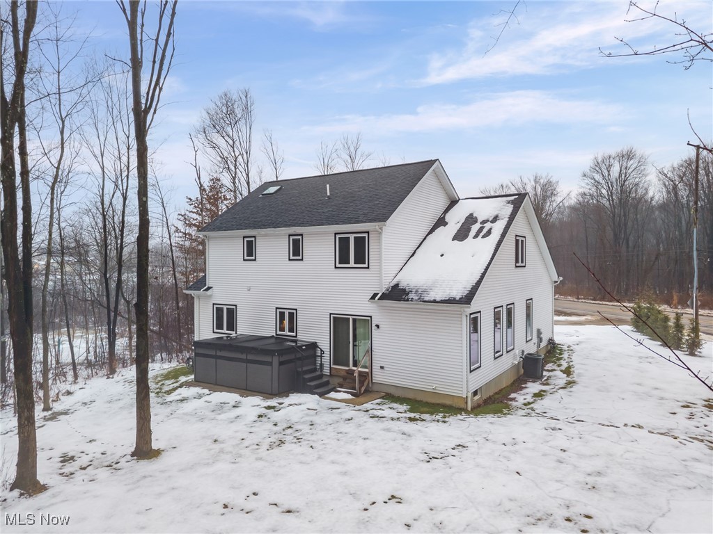 39600 Aurora Road Solon, OH 44139 - Photo 41 of 49 Snow covered house featuring a hot tub, a deck, and roof with shingles