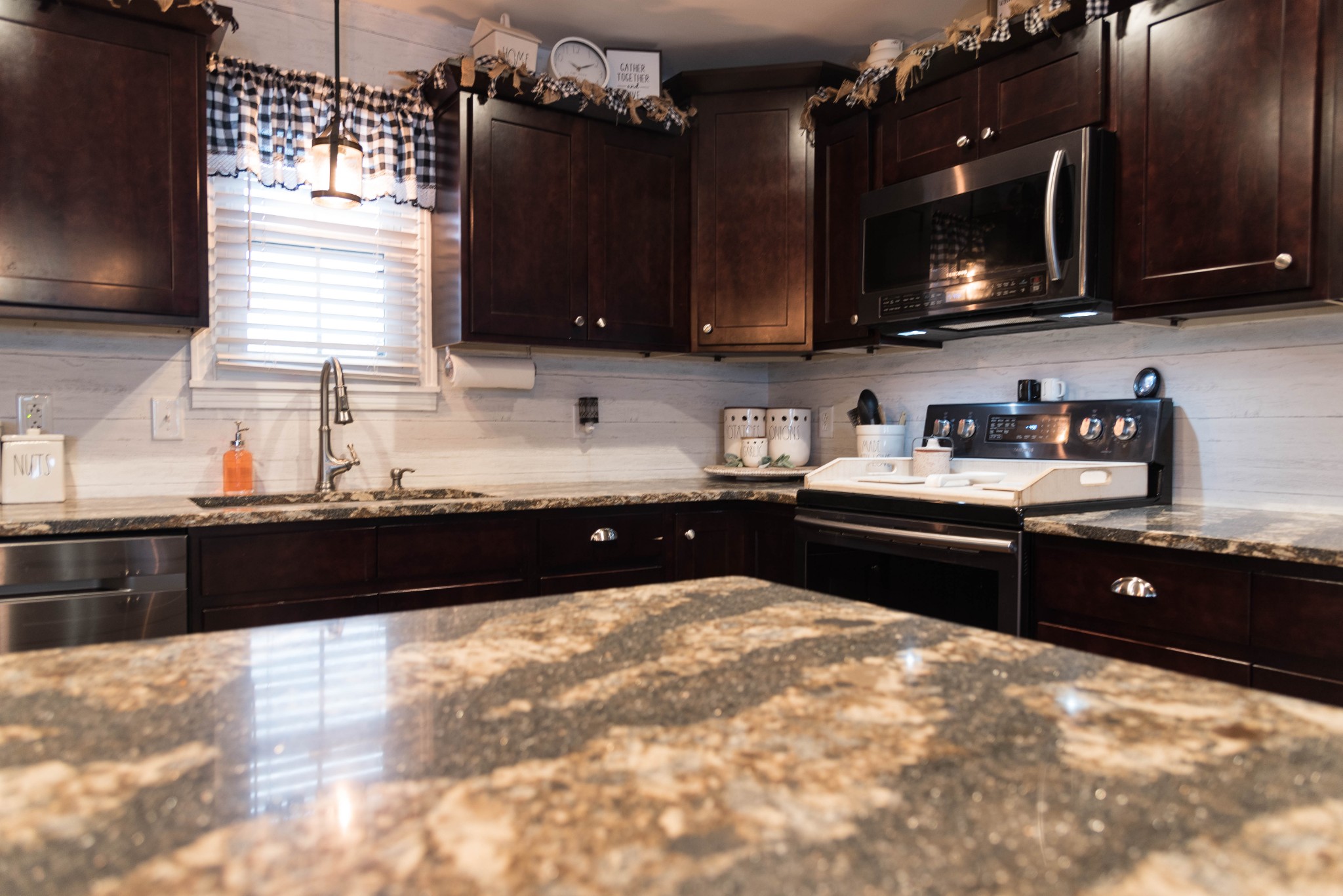 105 Biggs Road Cottontown, TN 37048 - Photo 10 of 40 a kitchen with a sink wooden cabinets and black appliances