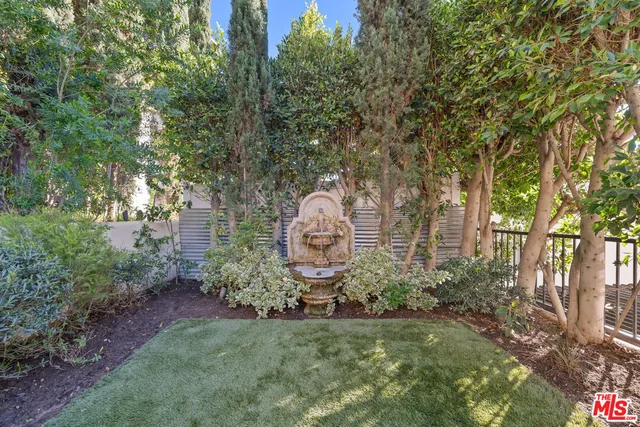 a backyard of a house with lots of green space and fountain view