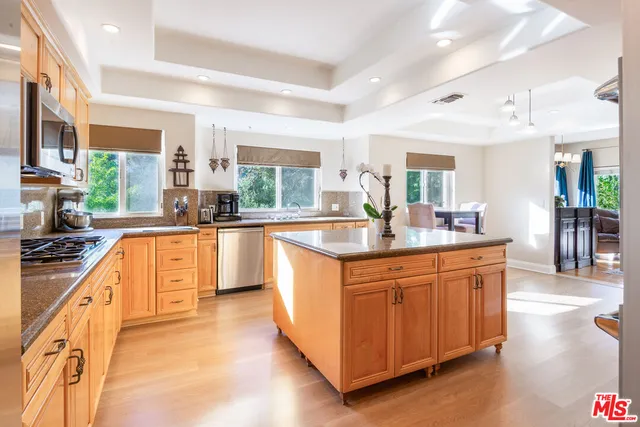 a kitchen with stainless steel appliances a sink stove and cabinets
