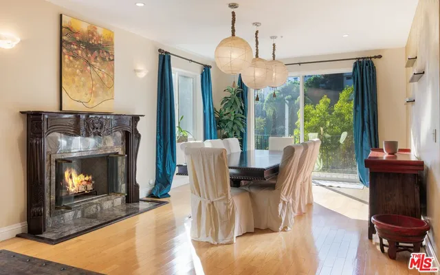 a dining room with furniture a fireplace and wooden floor